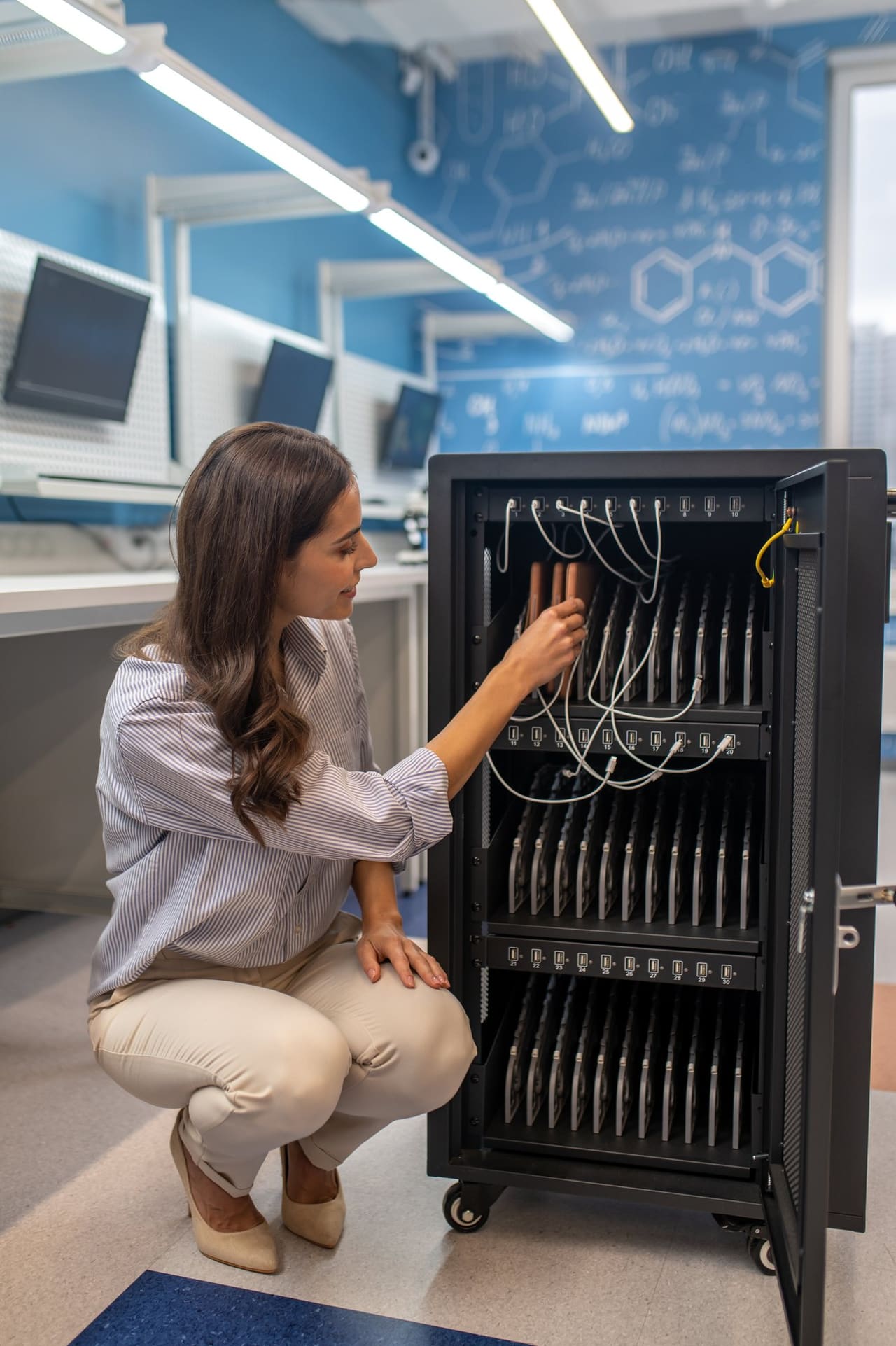 An engineer checks the cabling in an open network cabinet