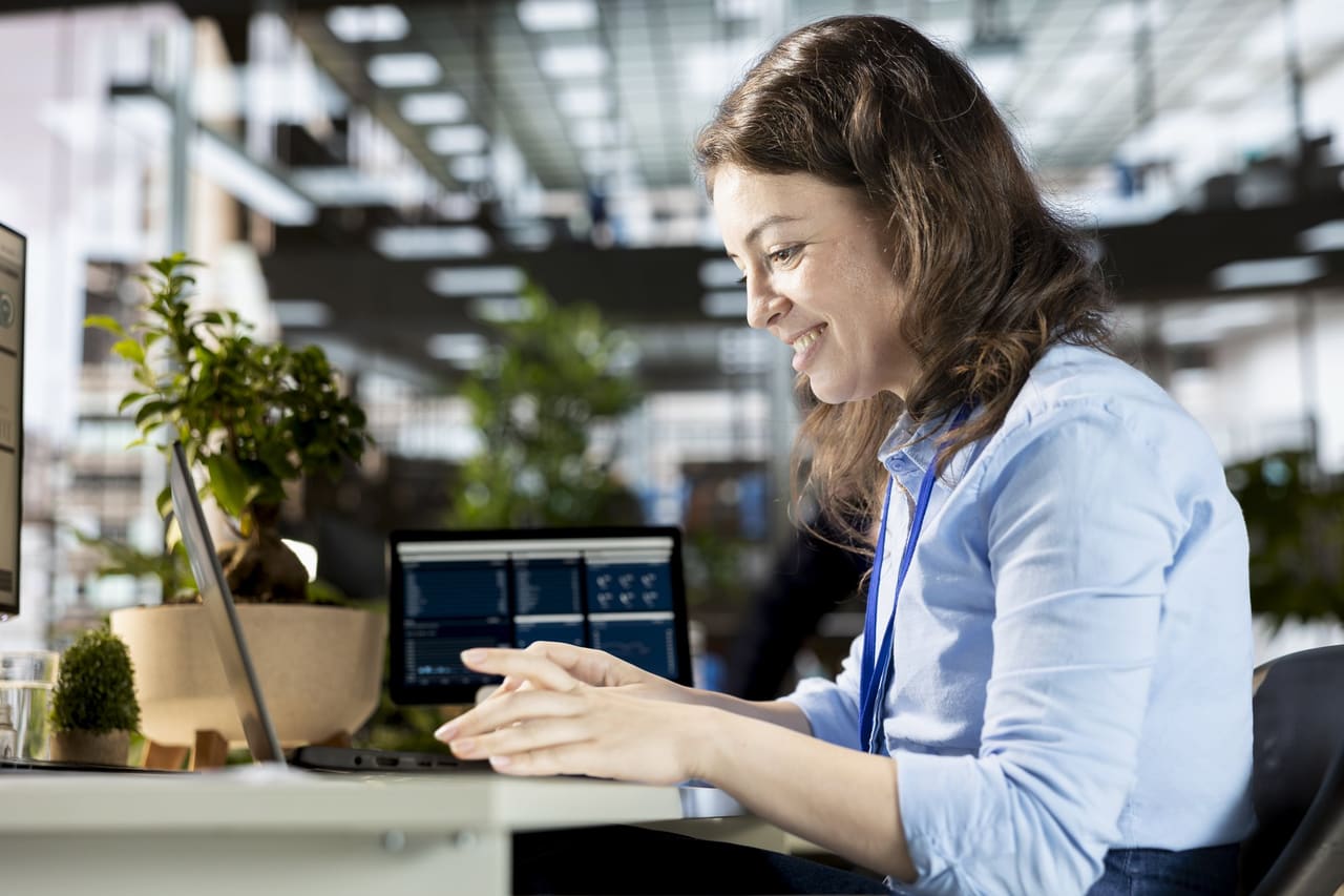 A finance lead at her desk with two screens
